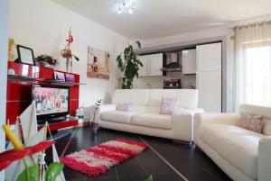 a living room with a white couch and a tv at Villacristiano in Marano Marchesato