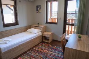 Habitación pequeña con cama, mesa y ventanas. en Bendida Village, en Pavel Banya 37 fotos más