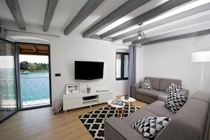 a living room with a couch and a tv at Apartment Panorama Antonia in Rovinj