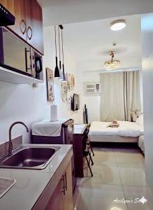 a kitchen with a sink and a room with a bed at Acellyne's Suites at Green 2 Residences with Netflix! in Dasmariñas