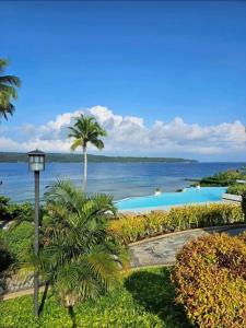 a view of a swimming pool and the ocean at Kembali Condo Unit For Rent in Magamomo