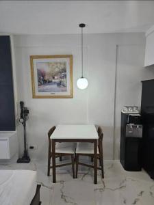 a dining room with a table and a picture on the wall at Kembali Condo Unit For Rent in Magamomo