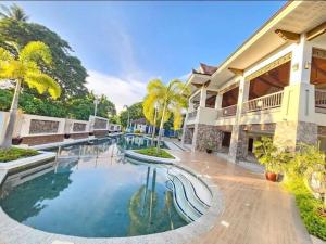 a swimming pool in front of a house at Kembali Condo Unit For Rent in Magamomo