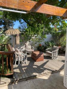 a patio with chairs and a table and an umbrella at Five Kingsway in Knysna