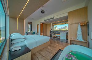 Gaotianにある桂林阳朔良宿 LS Hotel Liangsu Yangshuoの大型ベッドとバスタブ付きのホテルルームです。