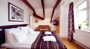 Clarion Collection Hotel Bilan في كارلشتاد: غرفة نوم مع سرير وفوط على طاولة
