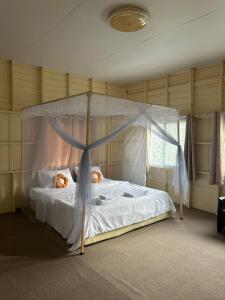 una camera da letto con un letto a baldacchino con orsacchiotti. di Garden house 