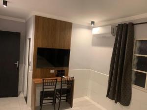 a kitchen with a table and a television in a room at Hotel Maya in São Paulo