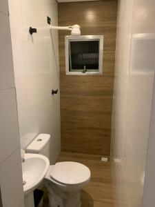 a bathroom with a toilet and a sink and a window at Hotel Maya in São Paulo