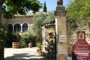 un bâtiment en pierre avec un panneau en face de celui-ci dans l'établissement Domaine Chanoine Rambert, à Saint-André-dʼOlérargues