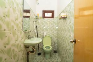 a bathroom with a green toilet and a sink at StayEase in Batticaloa