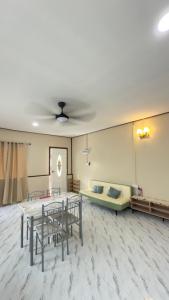 a room with a table and chairs and a couch at Perhentian Chatek Family Inn in Perhentian Islands