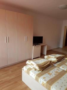 a bedroom with two beds and a desk with a television at Apartment Kraev in Primorsko