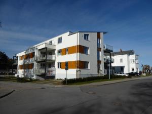 ein weißes Apartmenthaus an der Ecke einer Straße in der Unterkunft Strandhuhn in Juliusruh