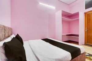 a bedroom with pink walls and a bed in it at SPOT ON Hotel Shivansh in Bhilai