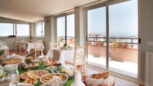 een tafel met eten in een kamer met ramen bij Sui tetti b&b in Alcamo