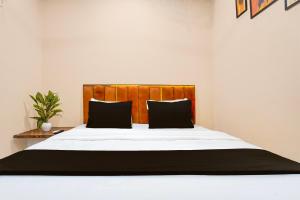 a bedroom with a large bed with black pillows at Hotel O Eden Stay in Bilāspur