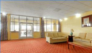 a living room with two couches and a table at Americas Best Value Inn & Suites Greenville in Greenville