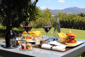 Le Daya Hotel et Spa في روكبرون-سور-أرجينس: طاولة مع أكواب من النبيذ والطعام عليها