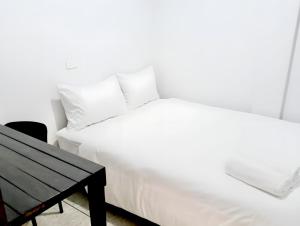 a bedroom with two white beds and a table at Mitr Inn Khaosan Road - มิตรอินน์ ถนน ข้าวสาร xPro in Bangkok