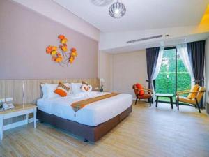 a hotel room with a bed and a desk and chairs at Chatnipa Beach Resort in Rayong +172 photos
