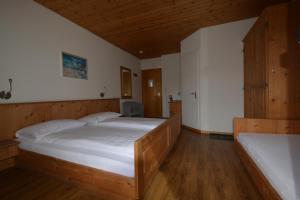 una camera con 2 letti e un soffitto in legno di Hotel Terminus a Samedan