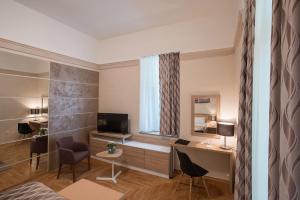 a living room with a television and a desk at Hotel Kurija Janković in Lukač