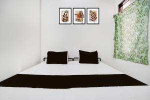 斋浦尔HOTEL O HOLIDAYS INN的卧室里有一张白色的床，上面有两个枕头