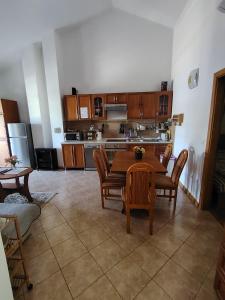 a kitchen with a wooden table and chairs and a table and chairsktop at Kopara apartmanok in Rogoznica