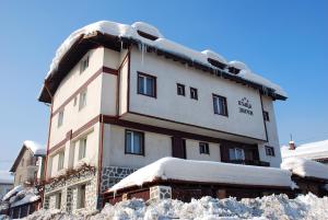 um edifício coberto de neve com neve à sua volta em Zigen House em Bansko