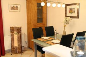 a dining room with a table and black chairs and a tableablish at Ferienwohnung Südblick in Groß Zicker in ruhiger Lage mit Terrasse und Meerblick in Groß Zicker
