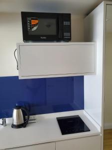 a microwave above a kitchen counter with a stove at Orbi C Block in Itʼkhvisi