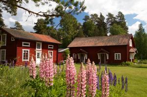 a garden with pink flowers in front of a red house at THE LODGE Torsby in Torsby +35 photos