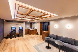 een wachtkamer met een bank en een geldautomaat bij Sotetsu Fresa Inn Yokohama Sakuragi-cho - Renovated in June 20th 2025 in Yokohama