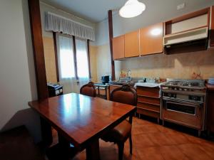 a kitchen with a wooden table and a wooden table and chairs at Bocasa affittacamere in Casaleone