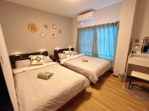 a bedroom with two beds and a window at Koyasui Guesthouse for Groups Easy Access to Yokohama & Shin-Yokohama in Yokohama