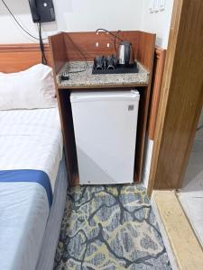 a small kitchen with a sink next to a bed at Elaf Al bait ايلاف البيت in Mecca