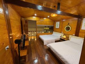 a bedroom with two beds in a wooden cabin at Honey Homes Cô Tô in Đảo Cô Tô