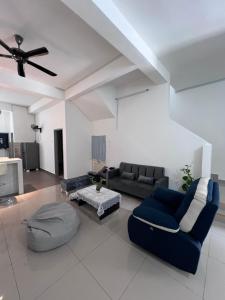 a living room with a blue couch and a table at Bentong Fun Homestay in Bentong