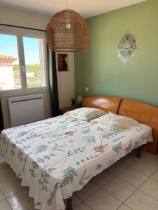 a bedroom with a bed with a blanket on it at Villa Familiale 3 Chambres avec Terrasse in Vergèze