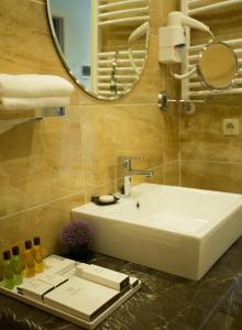 a bathroom with a white sink and a mirror at Bristol Central Park Hotel in Chişinău