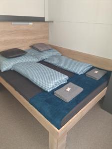 a bed with two pillows on top of it at Tin Men Apartmanház in Tiszafüred +31 photos