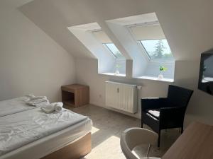 プットブスにあるHotel & Steakhouse am Schlossparkのベッドと机と2つの窓がある寝室
