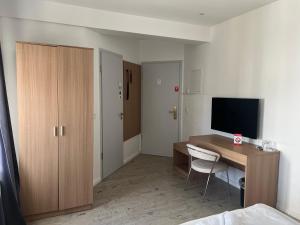 プットブスにあるHotel & Steakhouse am Schlossparkのテレビとベッドのある机のある部屋