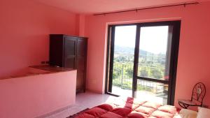 ein Wohnzimmer mit großem Fenster und Sofa in der Unterkunft Rio Rosa in Bova Marina