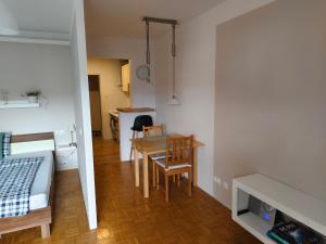 a small apartment with a table and a bedroom at Grünerbalkon Ferienappartement in Klagenfurt