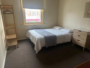アララトにあるArarat Hotelのベッドとドレッサーと窓のある寝室