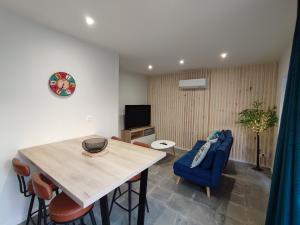 a living room with a table and a blue couch at Le Chai Vous in Grisolles