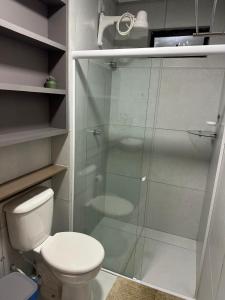 een badkamer met toilet en glazen douche bij Flat Varandas do Porto Residence in Porto De Galinhas +5 foto's