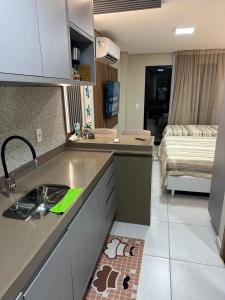 een keuken met een spoelbak en een woonkamer bij Flat Varandas do Porto Residence in Porto De Galinhas